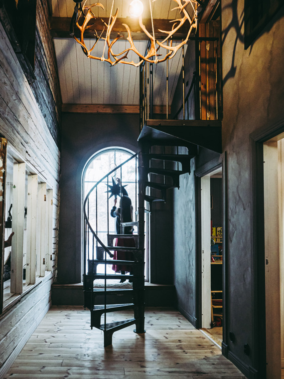 Nicole hangs a Christmas decoration in the large, arched window in the hallway.