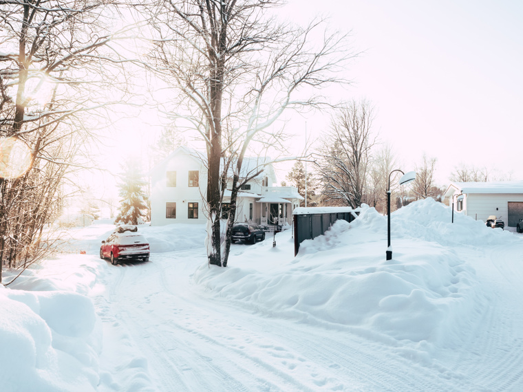 The sun is shining, and high snowbanks are surrounding the driveway that leads to the house where John lives.