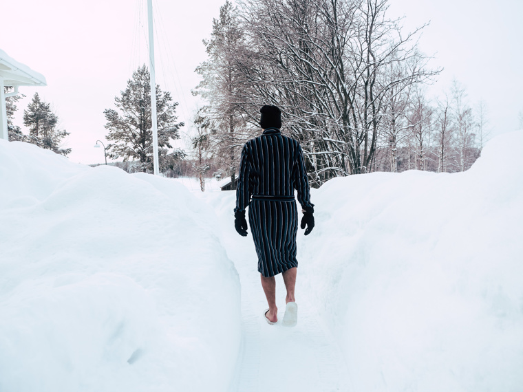 John wearing only a bathrobe, hat and slippers walks along the aisle he shot up to the shore.