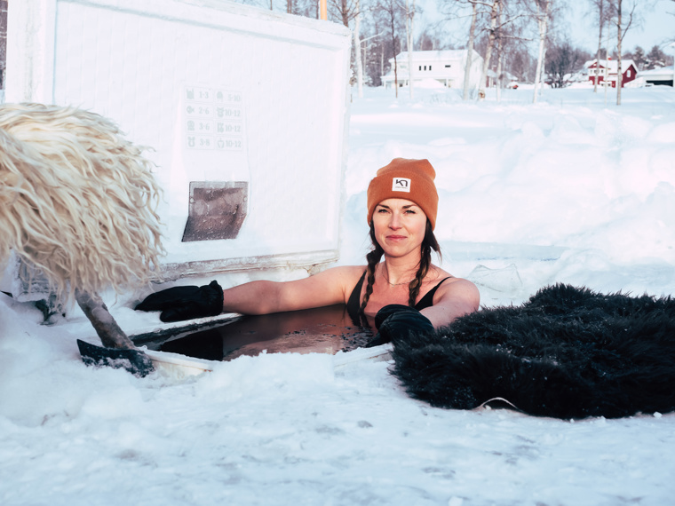 Maia, who looks quite relaxed, is sitting in the water. A sheepskin lying on the ice next to her.