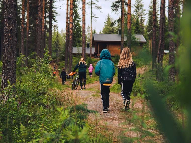 Familjerna promenerar längs stigarna som går genom skogen runt stugområdet.