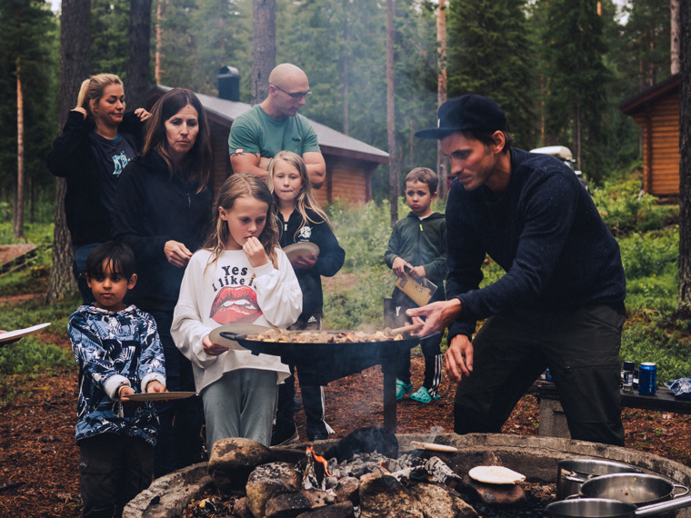 Both families have gathered around the barbecue ring and are cooking over the fire.